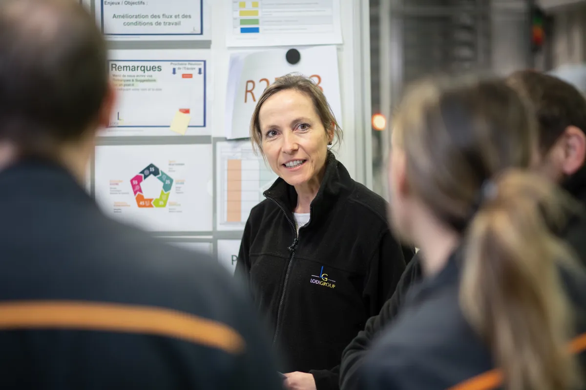 Une collaboratrice échange avec ses collègues dans l'atelier