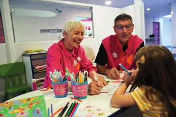 Bénévoles des Blouses roses en atelier avec un enfant