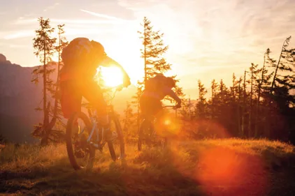Vététiste au coucher du soleil, club local soutenu